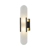 The Lirone 1 Light Large Vertical Capsule Alabaster Wall Light features an elongated alabaster shade and a black rectangular mount, emitting soft white light for a modern look.