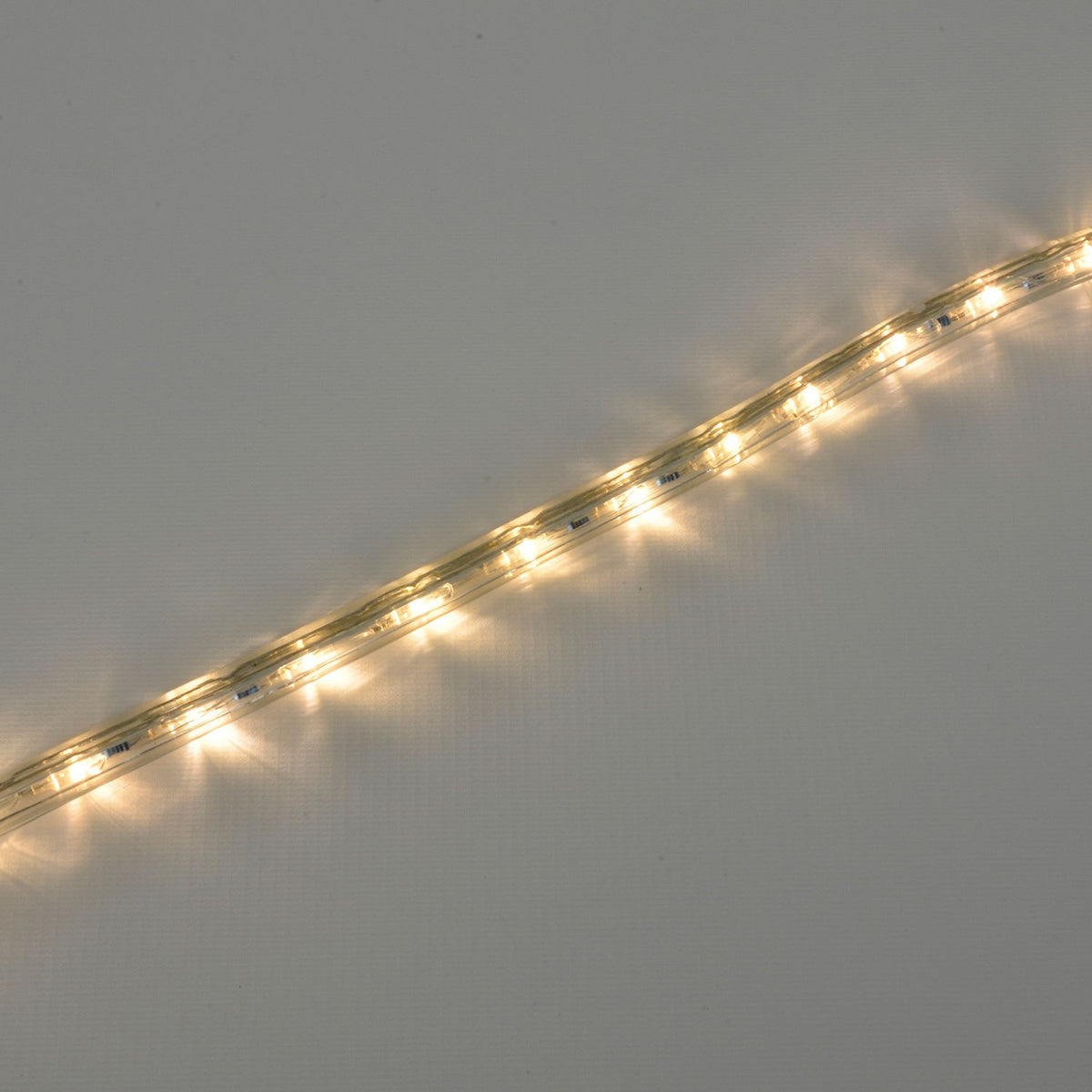 LYYT 50m LED rope light by AVSL shown illuminated diagonally in warm white 2800K along a clear flexible tube against a plain neutral background.