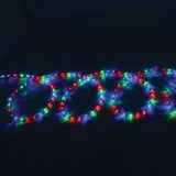 LYYT 50m multicolour LED rope light coiled in loops, glowing red, green, blue and white through a clear flexible tube against a dark background.