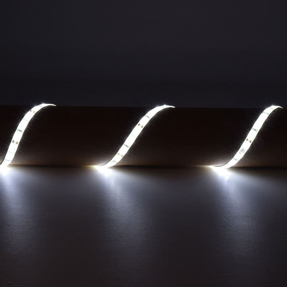 LYYT 12V LED strip light illuminated in cool white 6000K, draped in a wave formation over a cylindrical surface against a dark background.