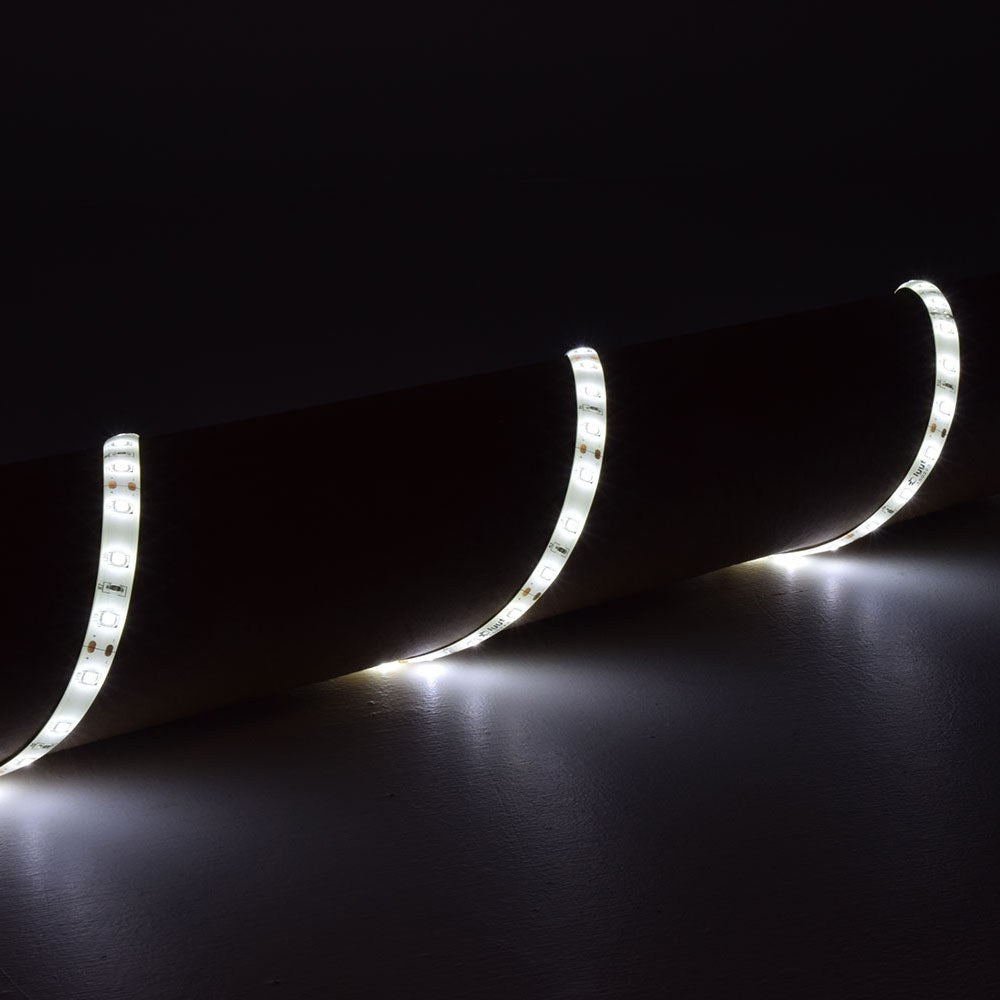 LYYT 12V LED strip light draped in curves, illuminated in cool white 6000K, showing flexible IP65 silicone tape with visible SMD LEDs against a dark surface.