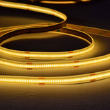 LYYT COBKITWW 24V COB 5m warm white LED tape coiled in loops, showing dense COB LEDs glowing along the flexible strip with 24V markings on the backing.