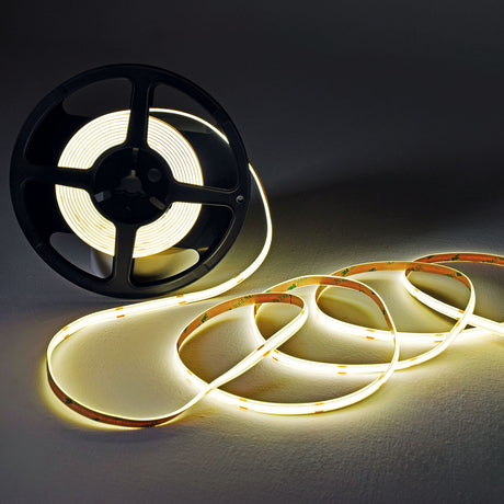 LYYT COBKITNW 24V COB LED tape kit shown partly wound on a black reel with the 5m strip unspooled in loops, glowing neutral white against a dark background.