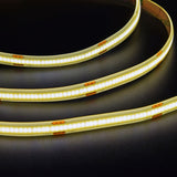 LYYT COBKITNW 24V COB LED tape coiled and illuminated, showing a continuous neutral white line of light along the slim strip with visible 24V+ cut markings.
