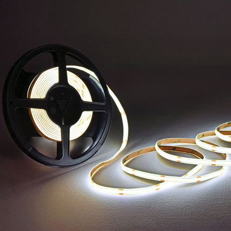LYYT COBKITCW 24V COB LED tape kit partially unwound from a black reel, showing 5m of cool white illuminated strip with 3M adhesive backing.