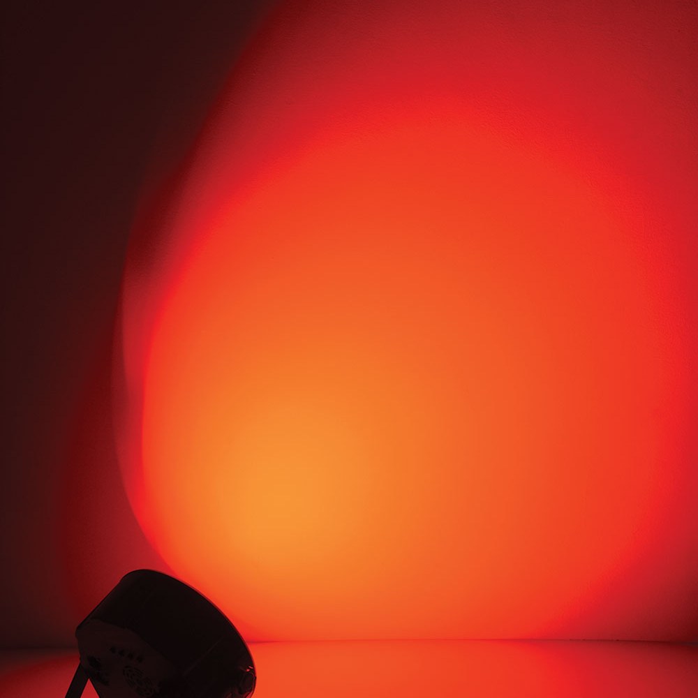 QTX 9x6W RGBW LED Par Can Light by AVSL on a floor, projecting a wide red wash across a dark wall from its low-profile black metal housing.