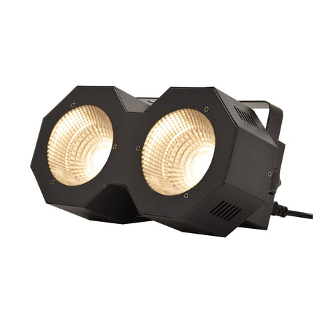 The QTX 2x50W High Power LED Wash Light features a black hexagonal casing with dual COB LEDs, displaying two side-by-side circular lights and includes a visible power cord—ideal for stage or studio use.