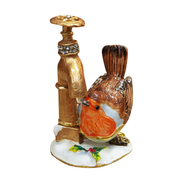 Hinged metal trinket box shaped as a brown robin with orange breast drinking from a gold tap, set on a white snowy base with holly, against a plain background.