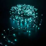 LYYT 960 LED cluster string lights by AVSL glowing in cool white and blue, dark green cable coiled against a black background.