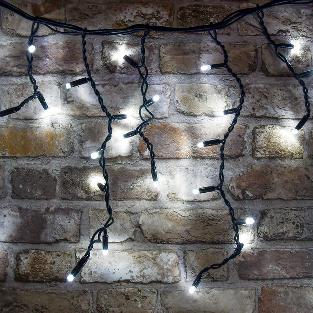 LYYT 180 LED outdoor icicle string light in cool white with black rubber cable and cascading drops shown lit against an exposed brick wall.