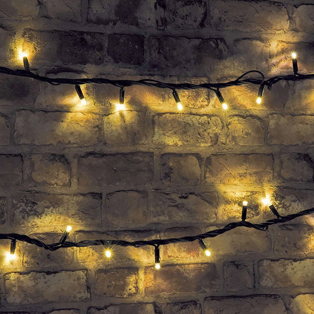 LYYT HD180C-WW warm white LED festoon string lights draped in two rows across a rustic exposed brick wall, glowing softly from small black-cased bulbs.