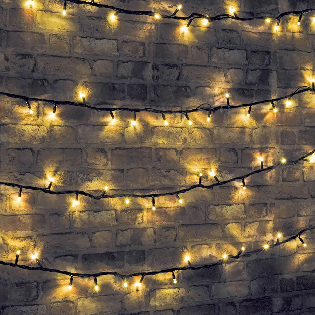 LYYT warm white LED festoon string lights draped in rows across a rustic brick wall, glowing bulbs spaced along a black cable.