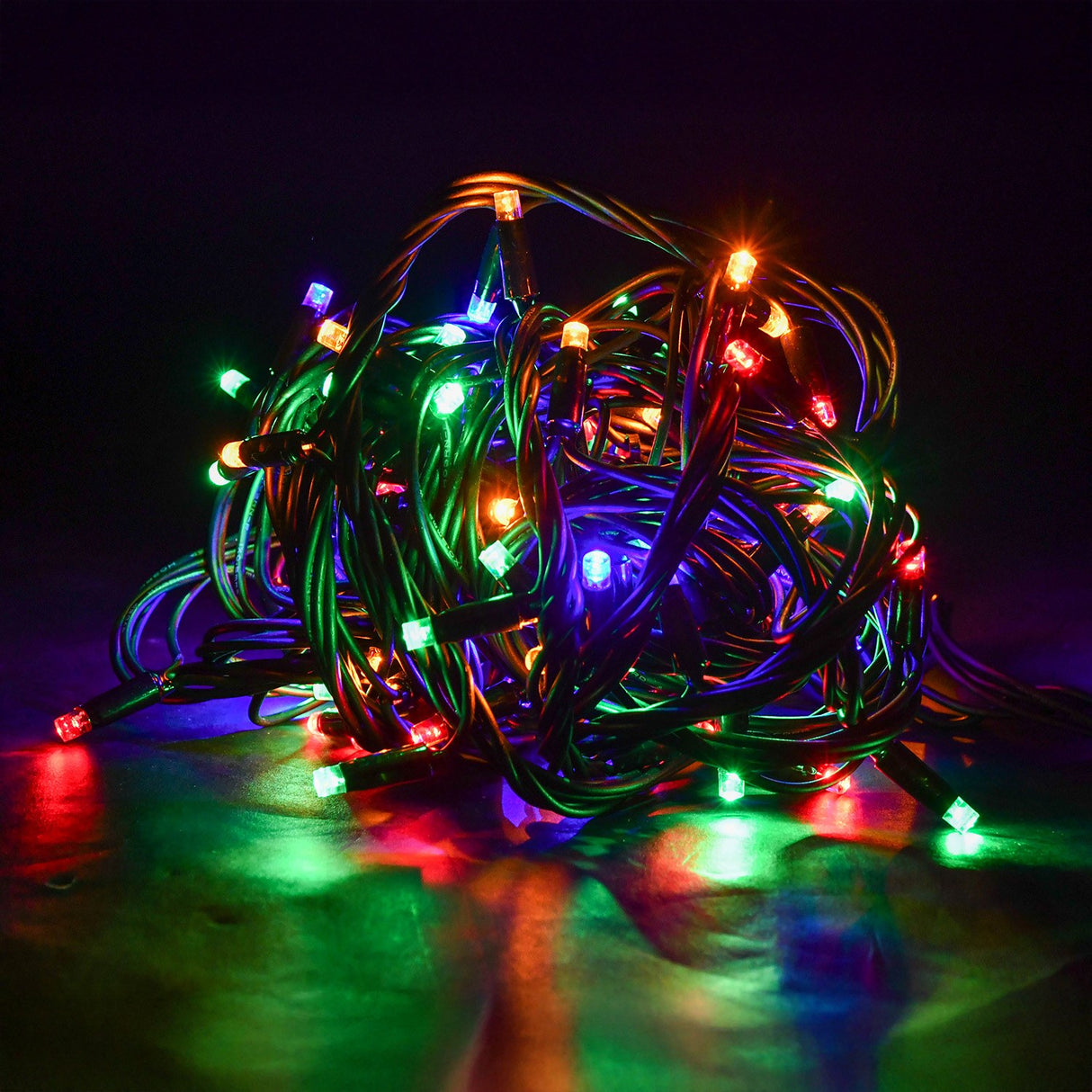 LYYT 90 LED heavy duty string lights coiled in a tangle, showing red, green, blue and amber LEDs glowing along black rubber cable with reflections.