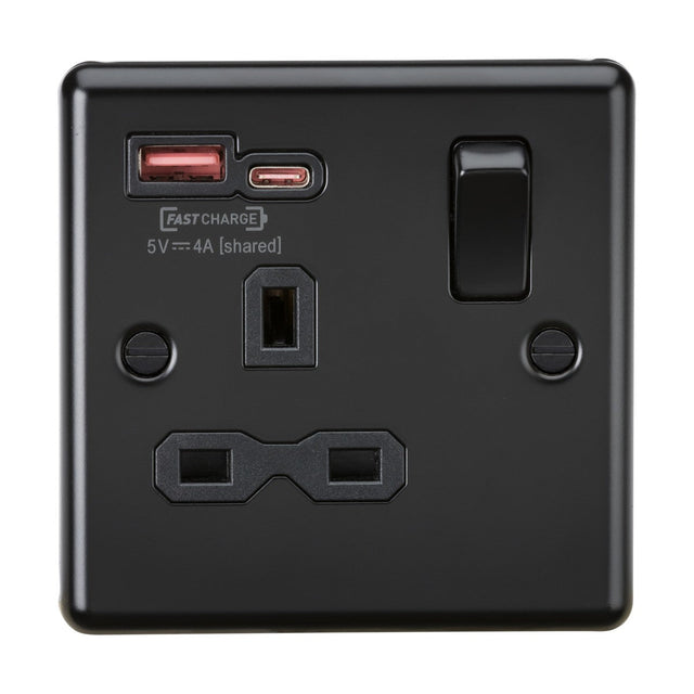 Introducing the 13A 1 Gang SP Switched Socket With Dual USB A+C in a sleek matt black finish, featuring a standard three-pin outlet. This socket is equipped with USB-A and USB-C ports labeled FASTCHARGE 5V 4A [shared] and supports both PD and QC charging protocols. The design includes a functional switch that enhances its modern appeal.