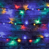 LYYT heavy duty RGBA festoon string lights draped across a brick wall, showing red, green, blue and amber LEDs illuminated on black rubber cable.