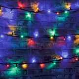 LYYT heavy duty RGBA festoon string lights draped in rows across a brick wall, glowing red, green, blue and amber on a black cable.
