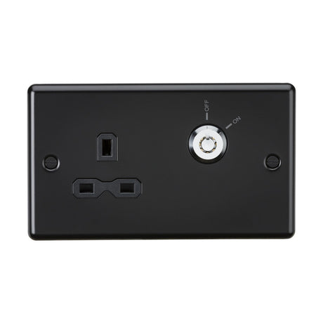 A matt black 13A DP key lockable socket with two plug openings for electrical devices is specifically designed for communal areas. Positioned to the right of the plug, it features a round switch labeled ON and OFF to emphasize its resistance to unauthorized use. This panel has a rounded edge and is mounted on a white background.