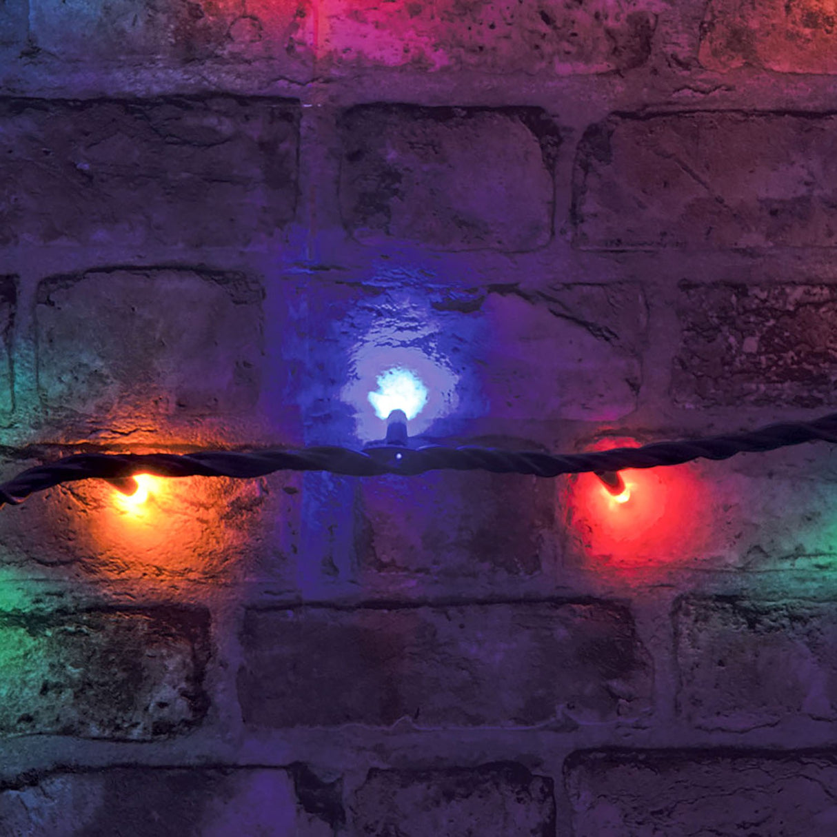 LYYT heavy duty festoon lights on black rubber cable, showing amber, blue and red RGBA LED bulbs glowing against a rustic brick wall.
