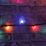 LYYT heavy duty festoon lights on black rubber cable, showing amber, blue and red RGBA LED bulbs glowing against a rustic brick wall.