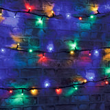 LYYT Heavy Duty Colour Festoon Lights draped across a dark brick wall in three rows, glowing red, green, blue, amber and white on black cable.