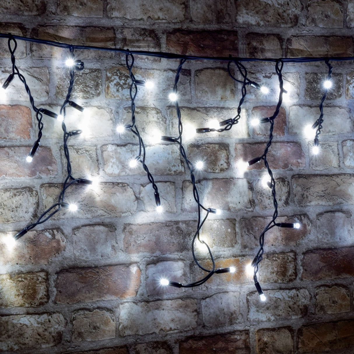 LYYT cool white LED icicle string lights with cascading drops on black cable, illuminated against an exposed brick wall.