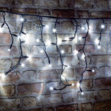 LYYT cool white LED icicle string lights with cascading drops on black cable, illuminated against an exposed brick wall.