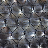 AVSL LYYT 144NET-CW cool white connectable net light with black rubber cable mesh and evenly spaced LEDs draped over a rustic brick wall.