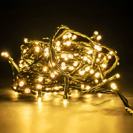LYYT 200 LED string lights coiled in a bundle with warm white concave bulbs glowing on a dark green cable against a dark background.