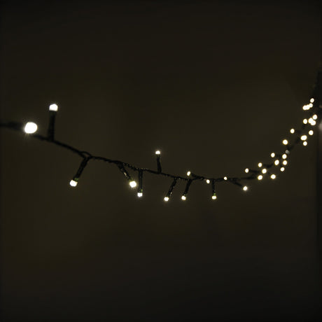 The LYYT 200 LED String Lights, with their warm white glow, hang against a dark background. These energy-efficient LEDs are evenly spaced along the 10-meter strand and emit a soft light that creates a cozy and inviting ambiance. The lights feature a convenient 24-hour auto-timer for added ease of use.