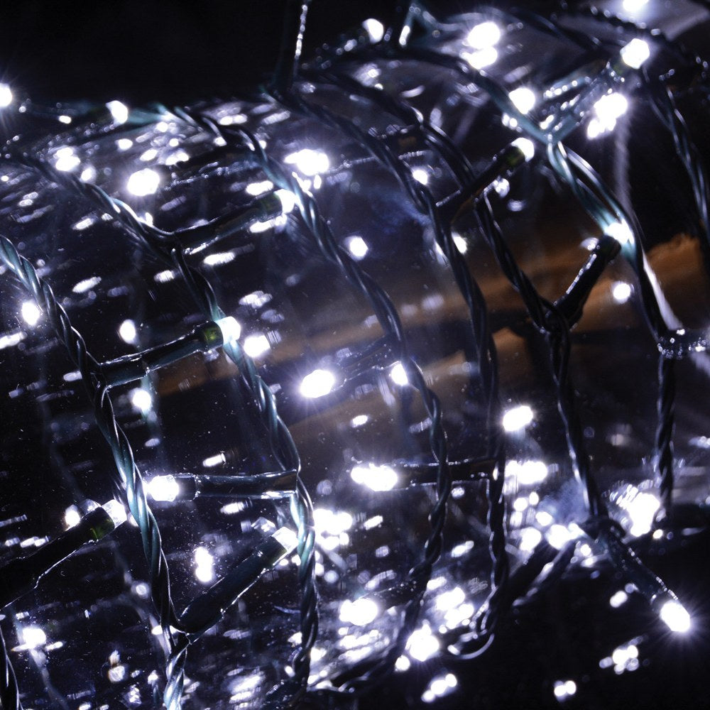 LYYT 200TS-CW cool white string lights coiled and illuminated, showing dense bright LEDs along a dark green PVC cable against a black background.