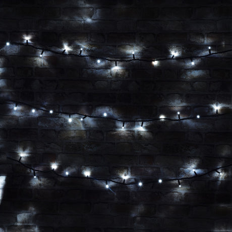 Against a dark brick wall, the LYYT 90 LED Heavy Duty LED String Lights glow softly with a cool white hue. These energy-efficient, 10-meter lights are designed for outdoor use and hang in horizontal rows, creating an ambient and cozy atmosphere.