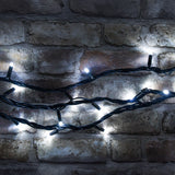 LYYT HD90C-WHT cool white LED heavy duty festoon string lights with concave bulbs on a black rubber cable, draped across a rustic exposed brick wall.