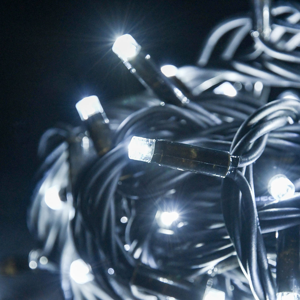 Close-up of LYYT HD90C-WHT Cool White Heavy Duty Festoon Lights by AVSL, showing illuminated concave LEDs along a coiled black rubber cable at night.