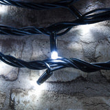 LYYT heavy duty festoon string lights coiled against a stone wall, with black UV-resistant rubber cable and a single cool white concave LED lit.