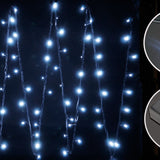 LYYT HD180C-WHT Cool White Connectable Festoon Lights by AVSL, shown lit at night with cool white LEDs draped vertically on black cables.