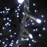 Close-up of LYYT HD180C-WHT cool white festoon string lights by AVSL, showing illuminated LEDs on black rubber cable against a dark background.