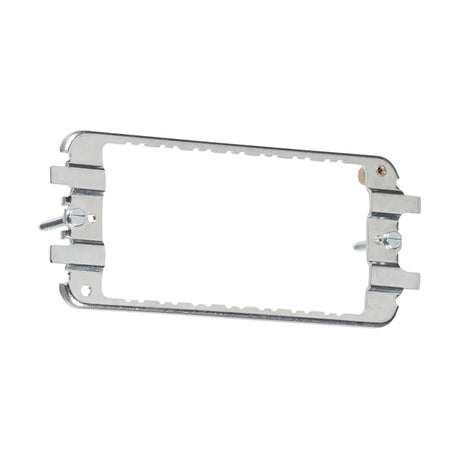 3-4 Gang Grid Mounting Frame for Flat Plate, Raised Edge & Metalclad, designed with screws on each side and featuring slots and holes for mounting. It has a silver finish with an open center, making it ideal for installation purposes in Metalclad Grid systems.