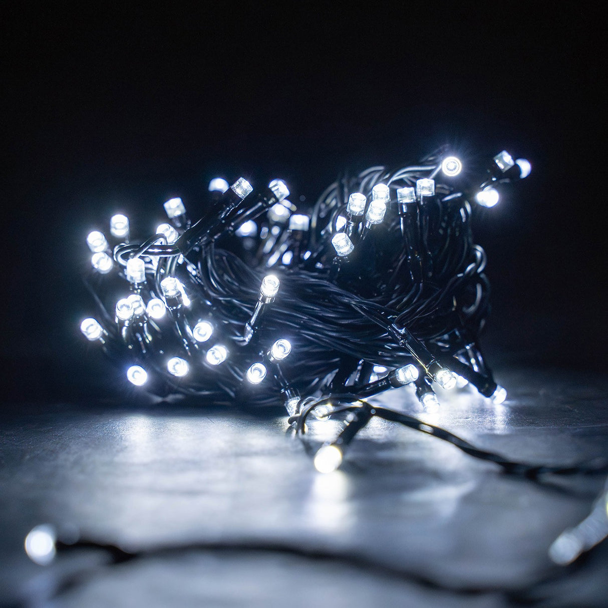 LYYT LED Battery Topiary Ball Light with 120 cool white LEDs on black cable, gathered in a lit cluster on a dark surface against a black background.