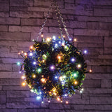 LYYT 120 LED battery topiary ball light with multicoloured LEDs on black cable wrapped around a green foliage ball, hung against a stone wall.