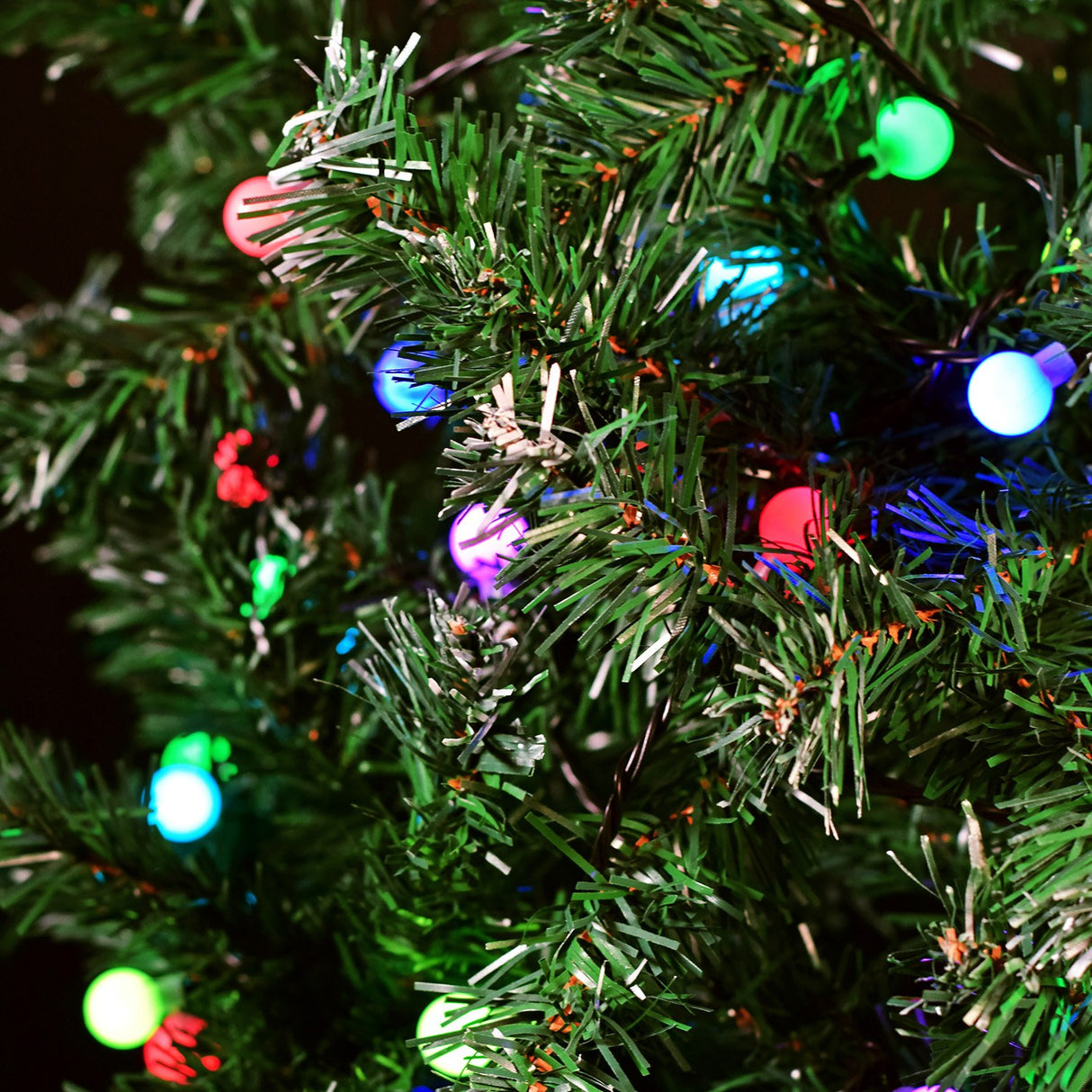 LYYT 20m multicolour berry string lights by AVSL shown lit on a green artificial Christmas tree with red, blue, green and pink LED globes.