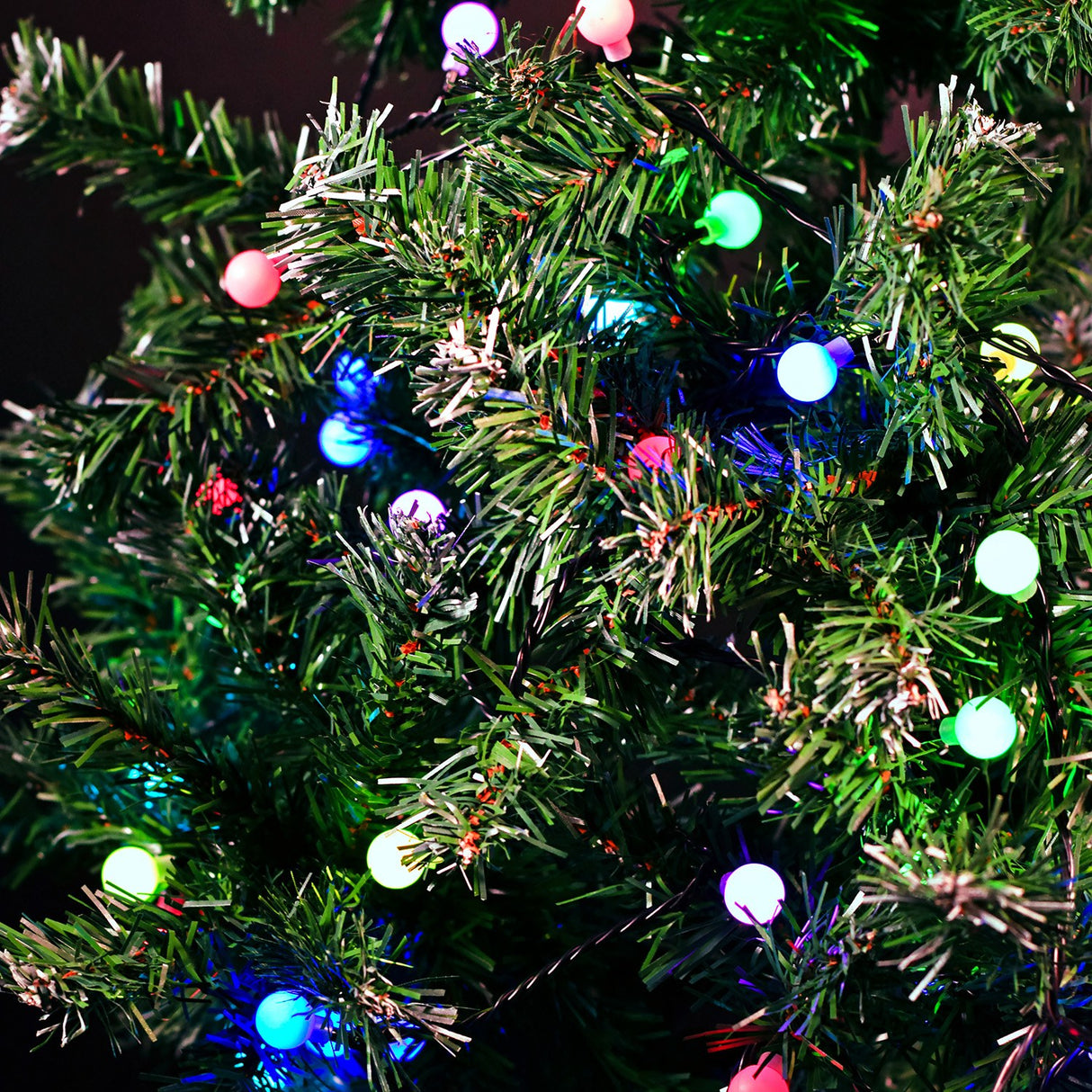 LYYT 20m multicoloured berry string lights illuminating a green artificial Christmas tree with pink, blue, green and white LED globes.