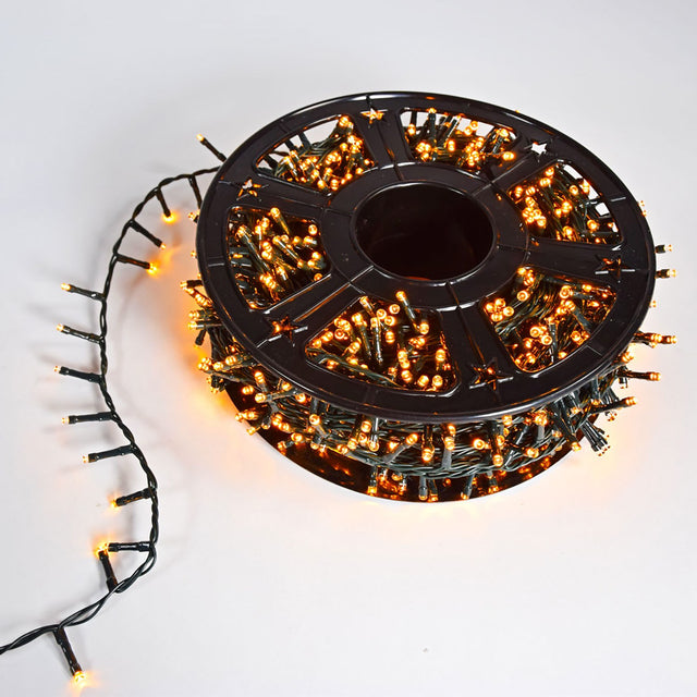 LYYT 45m amber 1500 LED string light reel by AVSL, wound on a black plastic spool with green cable and a lit strand trailing on a white background.
