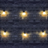 LYYT 10m festoon string with ten warm white LED globes on black cable, draped across a dark brick wall in an outdoor setting.