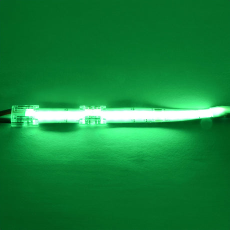 LYYT RGB COB LED strip connector joining two 10mm strip sections, clear housing with crimp tabs illuminated in bright green against a matching backdrop.
