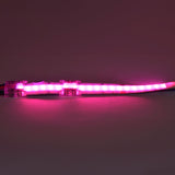 LYYT RGB COB LED strip connector joining a lit 10mm strip glowing pink, clear polycarbonate housing with crimp tabs visible on a neutral background.