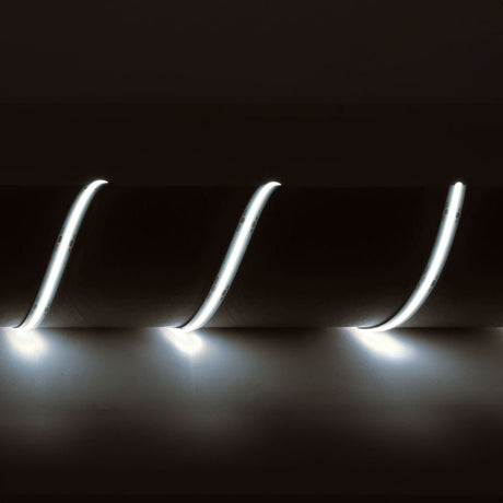 LYYT 24V COB LED strip light by AVSL shown lit in 6500K cool white, flexible silicone strip draped in three curves against a dark backdrop.