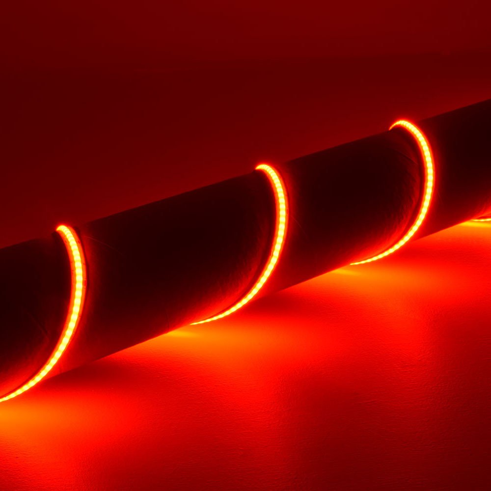 LYYT 24V COB RGB LED strip light by AVSL coiled and illuminated in red, showing the continuous seamless line of light across the flexible silicone strip.
