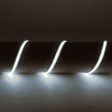 LYYT IP65 24V COB LED strip light by AVSL, 5m flexible tape wound around a cylindrical form, emitting cool white 6500K light against a dark background.