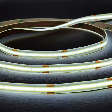 LYYT COB 24V LED tape by AVSL coiled in loops, illuminated in cool white along a slim flexible strip with visible 24V markings and 3M adhesive backing.