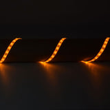 LYYT 12V Amber LED Strip Light draped in three curves over a cylindrical surface, glowing warm amber along the flexible IP65 tape against a dark background.